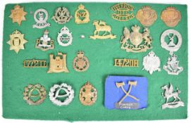 Twenty four cap badges, shoulder titles and insignia including Liverpool OTC, 2nd Battalion