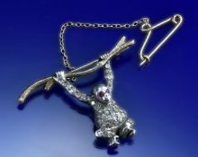 A 9ct gold and silver brooch in the form of a monkey set with diamonds and rubies, 6.7g, 3.5 x 2.4cm