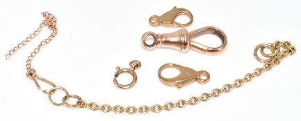 A 9ct gold dog clip (1.8g), two 9ct gold clasps (1g) and a 9ct gold safety chain (1.1g)