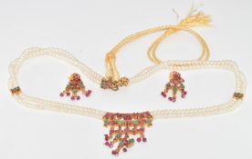 A double strand of cultured pearls with silver gilt pendant set with rubies and emeralds, with