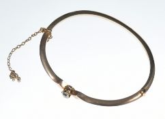 A 9ct rose gold bangle set with a round cut diamond of approximately 0.4ct, in antique box (hinge on