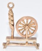 A 9ct gold charm in the form of a spinning wheel, 3.3g, 2.2cm