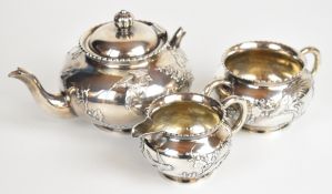 Wang Hing Chinese silver three piece teaset with embossed decoration of birds amongst foliage,