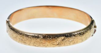 A 15ct gold bangle with engraved scrolling decoration, Birmingham 1918, 17.5g
