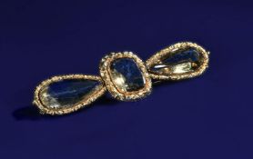 Victorian brooch set with a cushion cut and two pear cut citrines, with embossed floral border, 15.