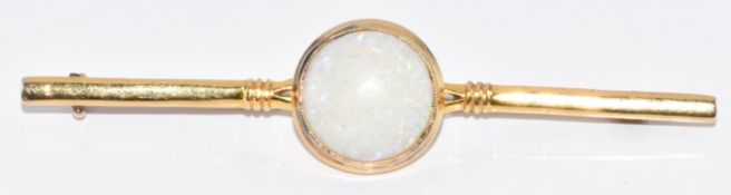A yellow metal brooch set with a round cut opal cabochon, tests as 18k, 5.8g, 6.6cm