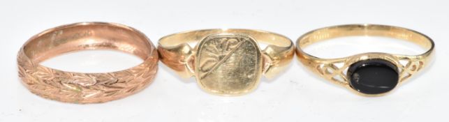 Three 9ct gold rings comprising one set with onyx, one signet ring and a wedding band, 3.2g, size P,