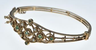 A 9ct gold bangle set with emeralds and pearls, 14.5g