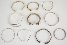 Ten silver bangles / torque bangles, two set with amethysts, one niello serpent and one with ram's