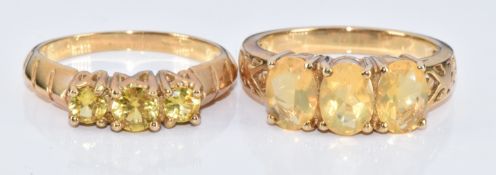 Two 9ct gold rings, one set with three round cut yellow sapphires and the other three oval cut