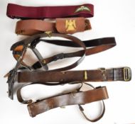 Five military style belts comprising four leather examples, some with storage space and one with a