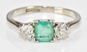 An 18ct white gold ring set with an emerald cut emerald of approximately 0.6ct and two round cut