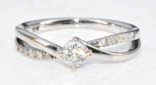 An 18ct gold ring set with a diamond of approximately 0.15ct and further diamonds to the