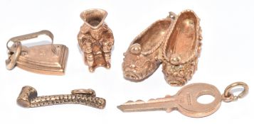 Five 9ct gold charms including shoes, toby jug, iron, key and pipe, 11.3g
