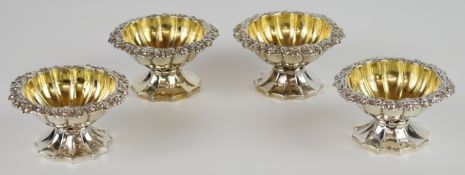 Set of four Georgian hallmarked silver pedestal open salts with decorative borders, lobed gilt