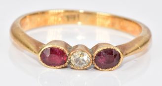 A c1900 18ct gold ring set with an old cut diamond and two oval cut rubies, 2.8g, size M