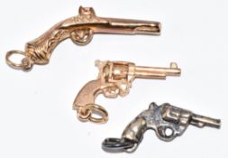Two 9ct gold charms in the form of guns (2g) and a similar silver example