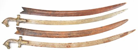 Two Indian / Persian Tulwar with 79cm single edged curved steel blades, hilt decorated with a