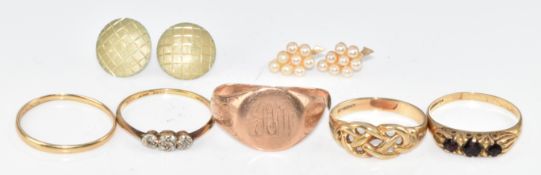 An 18ct gold ring set with three diamonds in a platinum setting (1.4g), four 9ct gold rings