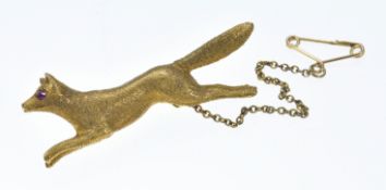 A 15ct gold brooch with textured finish in the form of a fox set with a ruby eye,10.2g, 4.2cm
