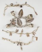 A silver charm bracelet with floral and foliate charms and three silver bracelets with dragonfly,