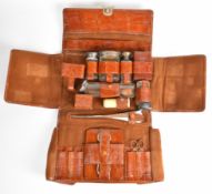Early 20th century gentleman's travelling vanity set in crocodile skin fold out case, including