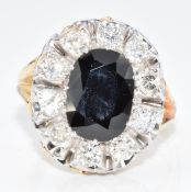 An 18ct gold ring set with an oval cut sapphire of approximately 2.8ct surrounded by ten round cut