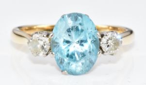 An 18ct gold ring set with an oval cut zircon of approximately 1.6ct and two round cut diamonds,