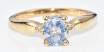 A 9ct gold ring set with an oval cut sapphire of approximately 0.7ct and white sapphires, 2.8g, size