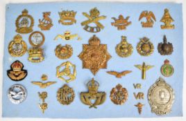 Approximately 28 cap badges, mostly Naval related, including Drake Battalion, Nelson, Howe, Steady