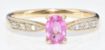 A 9ct gold ring set with an oval cut pink sapphire of approximately 0.5ct and diamonds, 1.8g, size
