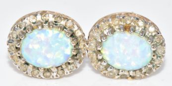 A pair of 9ct gold earrings set with synthetic opals surrounded by diamonds, 3.1g