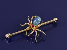 A c1900 15ct gold brooch in the form of a spider set with a black opal cabochon and an oval cut