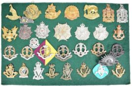 Thirty two cap badges and insignia, many examples from the King's Colonial Forces including