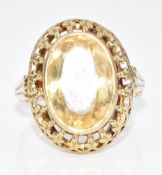 A 333 gold ring set with an oval cut citrine within a pierced border, 3.8g, size M