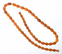 A single strand of Baltic amber made up of fifty oval beads, largest bead 9.9 x12.8mm and the