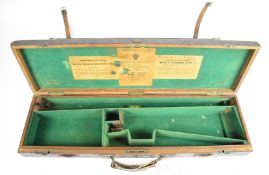 Two vintage leather bound oak shotgun carry cases, both with fitted interiors and one with '
