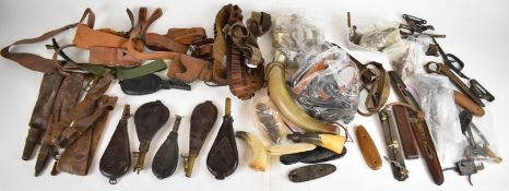 A collection of vintage gun and shooting accessories including leather shot flasks, cartridge belts,