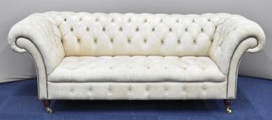 Leather / faux leather Chesterfield sofa raised on turned legs and brass castors, W227cm