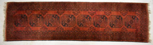 Afghan runner with a single line of guls on a wine ground, 285 x 78cm