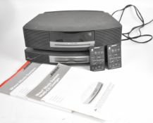 Bose Wave music system together with multi-CD changer, remote controls and manuals.