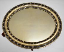 19thC Irish oval wall mirror, with a parcel gilt and jewelled ebonised frame, maximum diameter 73cm