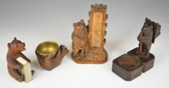 Four 19th/20thC carved Black Forest bear figures including a menu holder, saltbox, matchbox holder