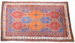 Turkoman rug with alternate blue, red and orange guls on a wine ground, within figural animal and
