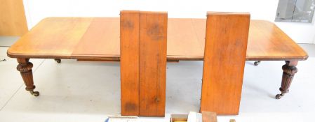 Victorian oak wind out extending dining table with five legs and seven extra leaves and brass