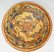 Studio pottery charger decorated with lions circling their prey, signed verso SIL and a cross with