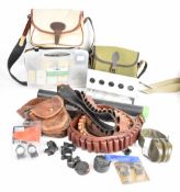 A collection of gun and shooting accessories including two shotgun cartridge bags, three shotgun