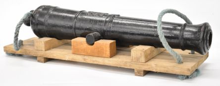 Cast iron 2 inch bore cannon with crown over GR cypher and 30 inch barrel, on wooden carrier.