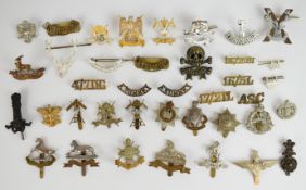 Approximately 36 cap badges and shoulder titles comprising 9/12th Lancers, 16th Lancers, Royal Scots