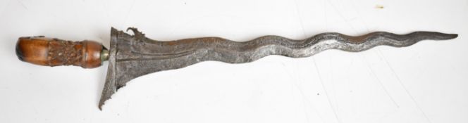 South East Asian or similar Kris dagger with 35cm wavy blade and ornately carved wooden handle.